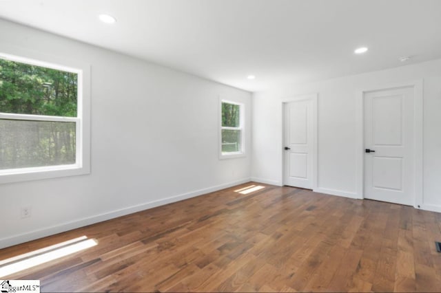 spare room featuring baseboards, recessed lighting, and wood finished floors