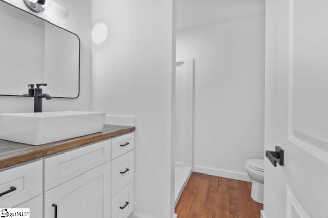 full bathroom featuring baseboards, vanity, toilet, and wood finished floors