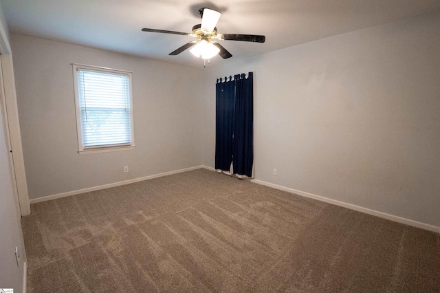 carpeted empty room with baseboards and a ceiling fan