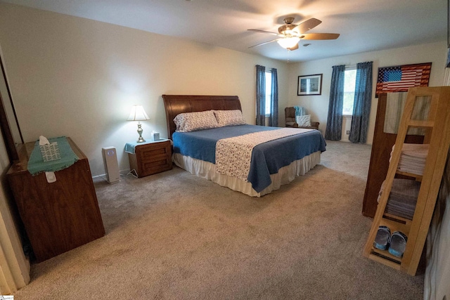 bedroom with a ceiling fan and light carpet