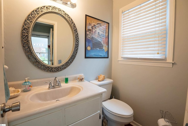 half bathroom featuring vanity and toilet