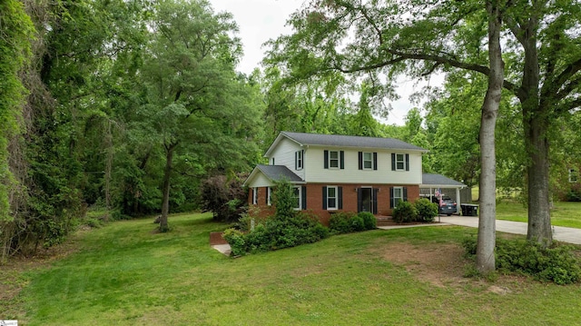 view of front of property featuring brick siding, driveway, a carport, and a front lawn