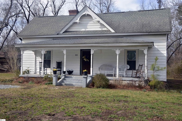 view of front of property featuring roof with shingles, covered porch, and a chimney