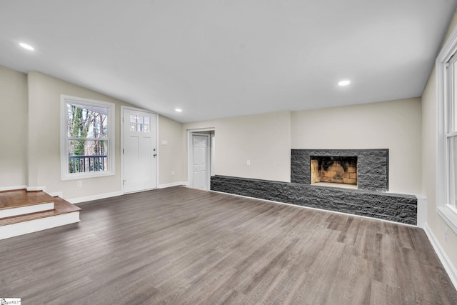 unfurnished living room with a premium fireplace, recessed lighting, baseboards, wood finished floors, and vaulted ceiling