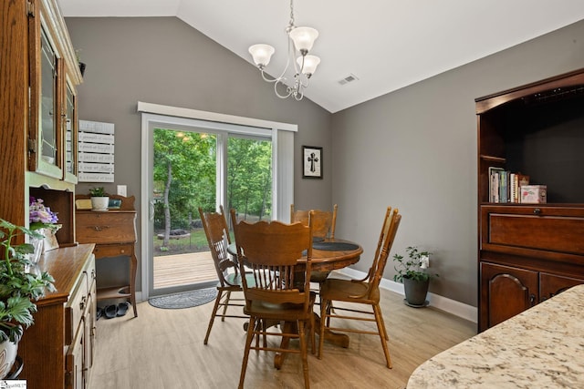 dining room featuring a notable chandelier, vaulted ceiling, light wood-style flooring, and visible vents