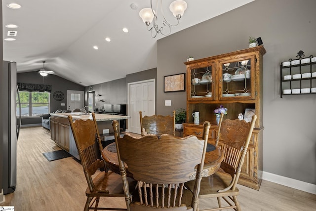 dining room featuring light wood finished floors, ceiling fan with notable chandelier, recessed lighting, baseboards, and lofted ceiling