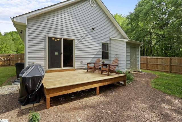 rear view of house with a fenced backyard and a wooden deck