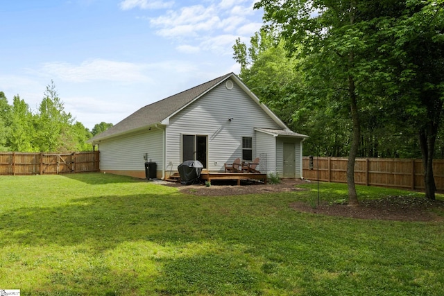 back of property featuring a fenced backyard, a yard, and a deck