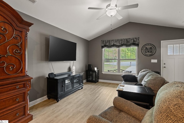 living area with vaulted ceiling, baseboards, a ceiling fan, and light wood-type flooring