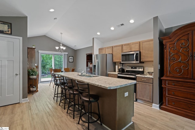 kitchen with visible vents, lofted ceiling, light countertops, a sink, and appliances with stainless steel finishes