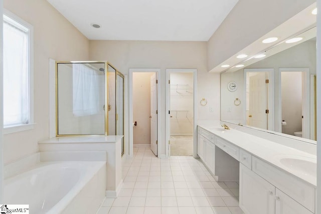 full bathroom featuring tile patterned flooring, toilet, a bath, a sink, and a stall shower