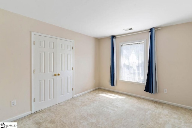 unfurnished bedroom with visible vents, baseboards, carpet floors, and a closet
