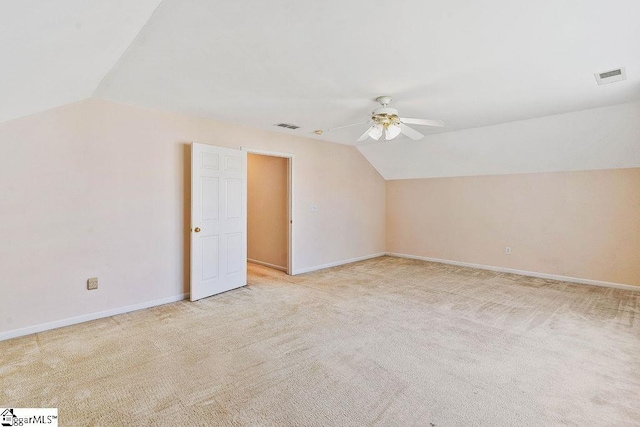 additional living space featuring ceiling fan, visible vents, baseboards, lofted ceiling, and light carpet