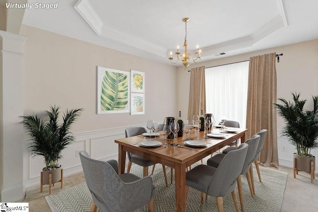 dining area featuring light colored carpet, a tray ceiling, a chandelier, and ornamental molding