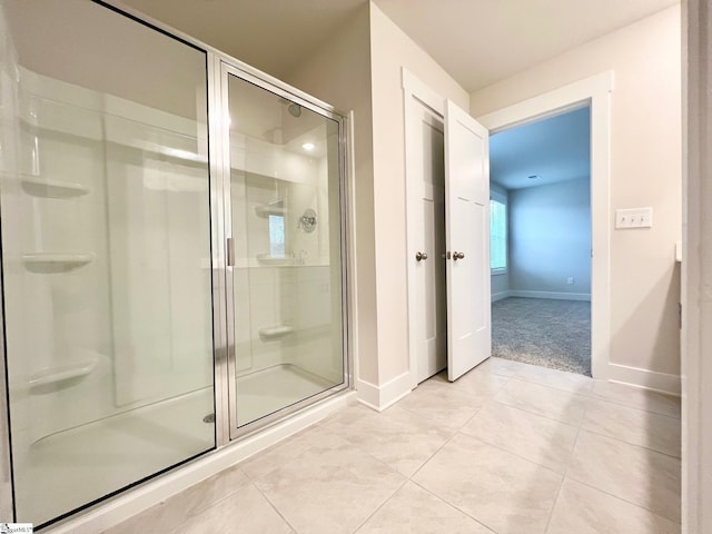 full bathroom with baseboards, a stall shower, and tile patterned flooring