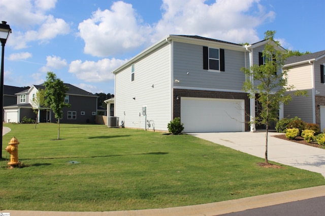 view of front facade featuring a front yard, brick siding, central AC, concrete driveway, and an attached garage