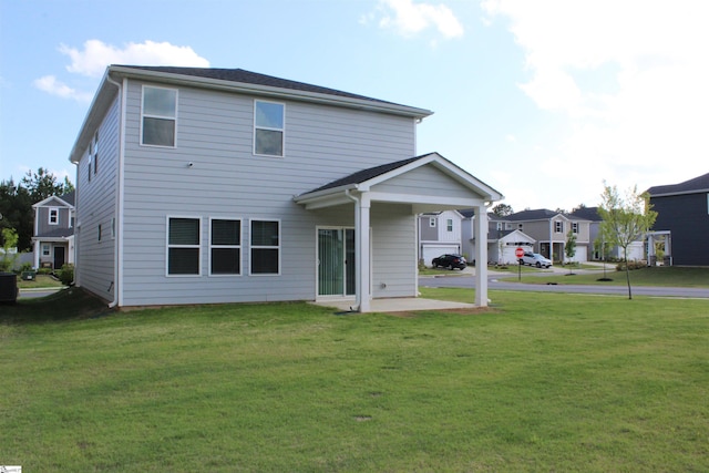 back of house featuring a patio and a yard