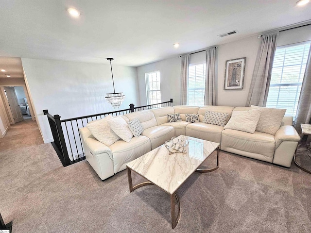 carpeted living room featuring recessed lighting, visible vents, and an inviting chandelier