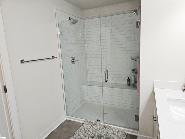 full bath featuring vanity, baseboards, and a stall shower