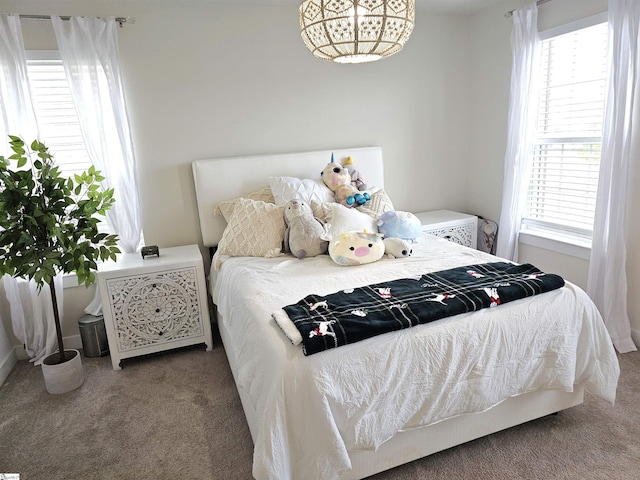 carpeted bedroom with a chandelier