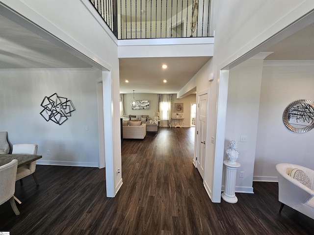 entrance foyer with dark wood-style flooring, baseboards, recessed lighting, and a towering ceiling