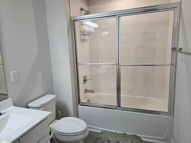 full bath with vanity, bath / shower combo with glass door, and toilet