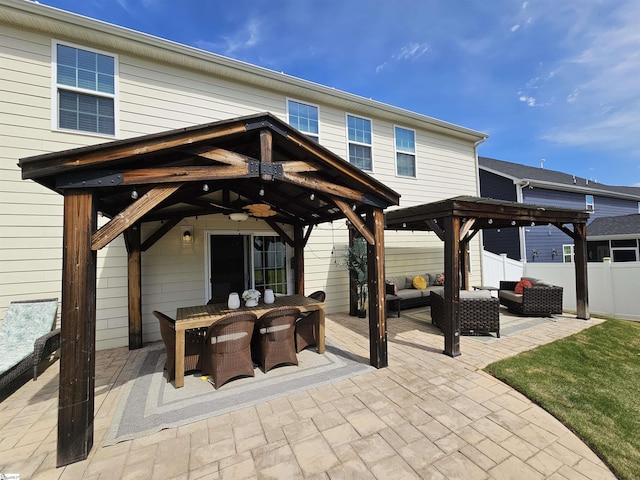 view of patio / terrace featuring outdoor lounge area, fence, outdoor dining area, a ceiling fan, and a gazebo