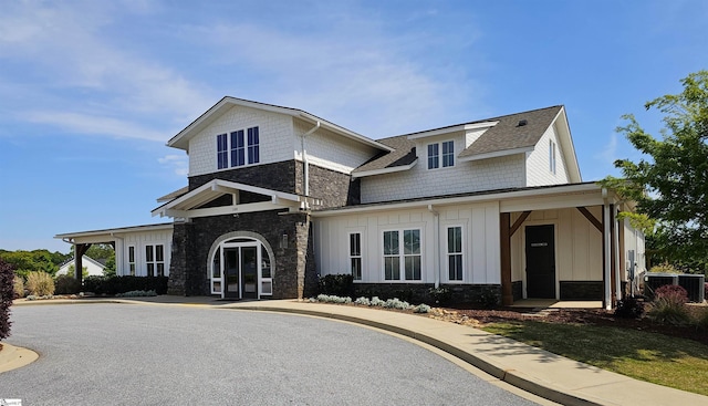 view of front of home featuring board and batten siding, central AC, and stone siding
