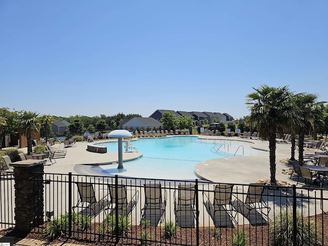 pool with a patio area and fence