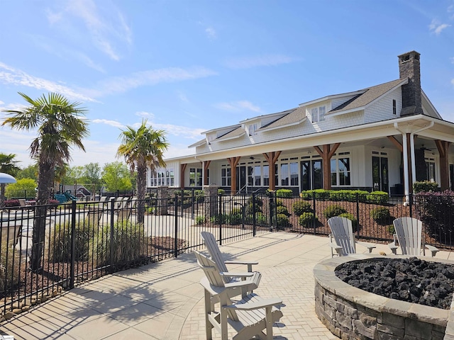 view of patio / terrace featuring fence and a fire pit