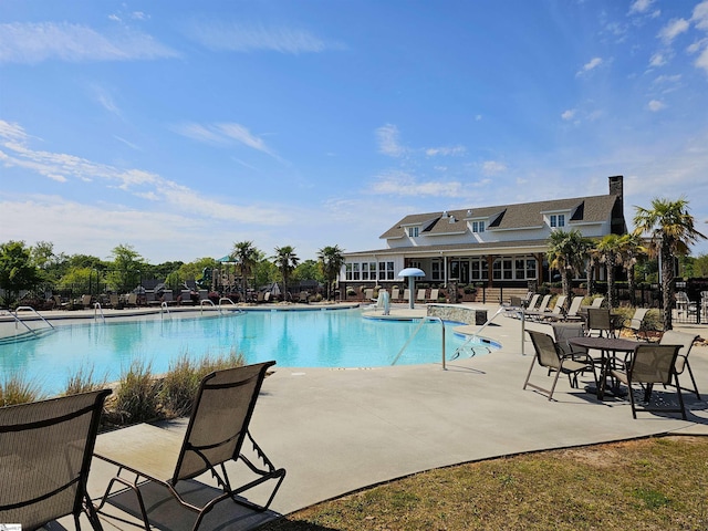 community pool with fence and a patio area