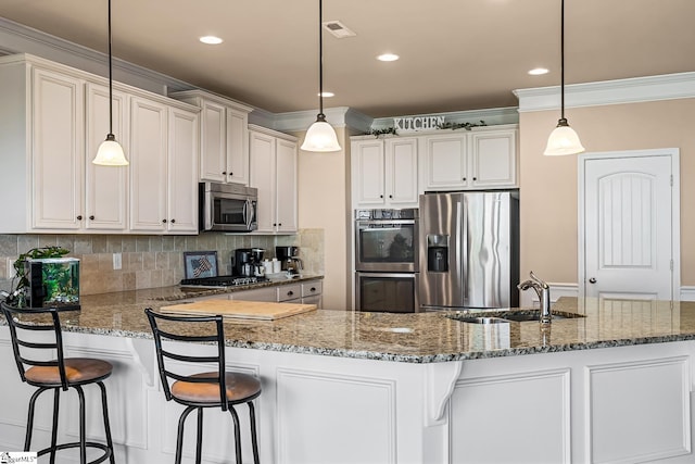 kitchen with visible vents, ornamental molding, dark stone counters, a sink, and appliances with stainless steel finishes