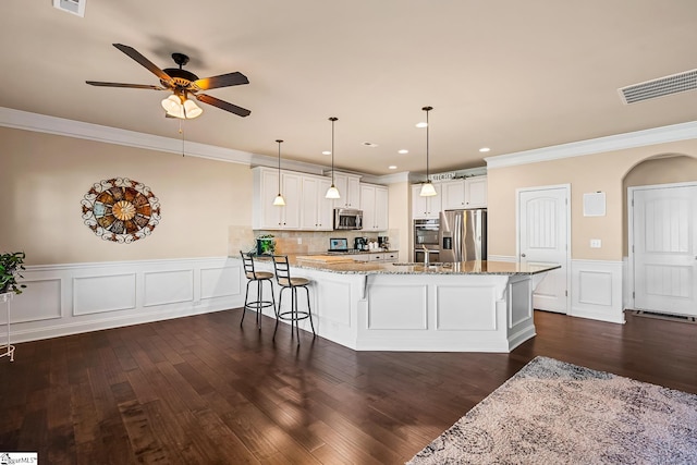 kitchen featuring crown molding, a peninsula, appliances with stainless steel finishes, and visible vents