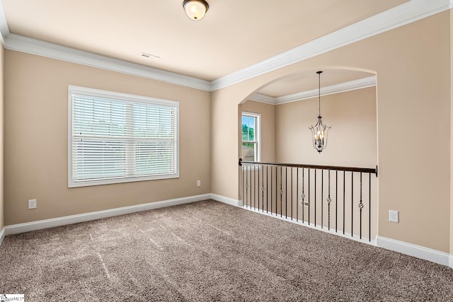 carpeted spare room featuring visible vents, ornamental molding, baseboards, a chandelier, and arched walkways