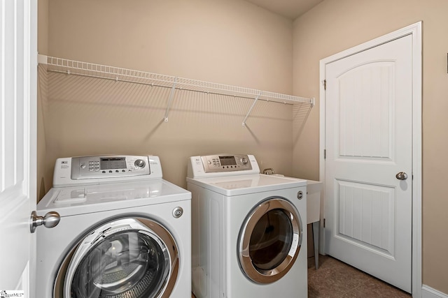 clothes washing area featuring separate washer and dryer and laundry area