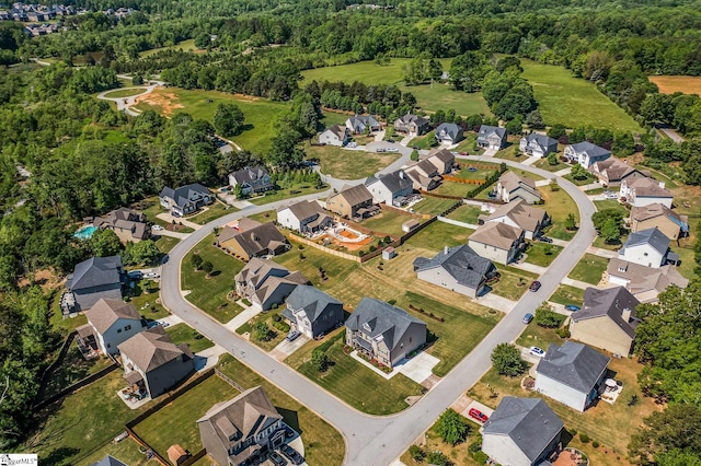 bird's eye view featuring a residential view and a wooded view