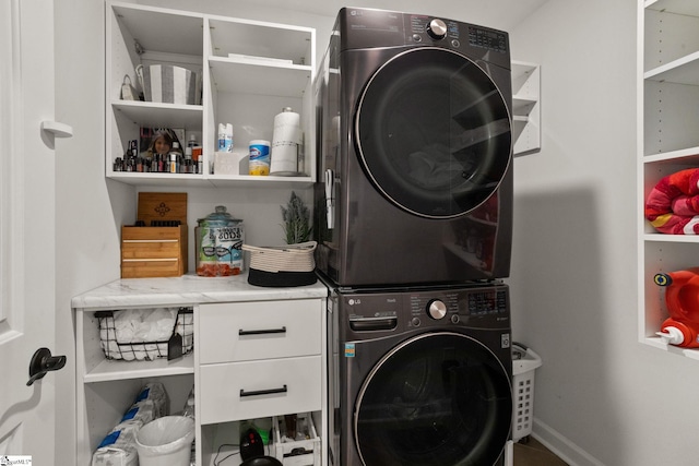 laundry room featuring cabinet space and stacked washing maching and dryer
