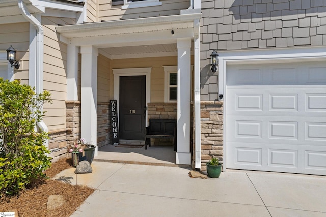 property entrance featuring a garage, driveway, and stone siding