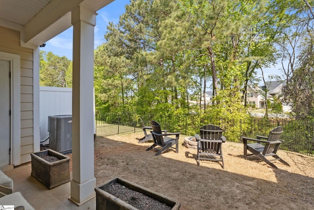 view of patio with central air condition unit, a fire pit, and a fenced backyard