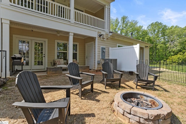 view of patio / terrace featuring fence, an outdoor fire pit, central AC unit, a balcony, and a ceiling fan