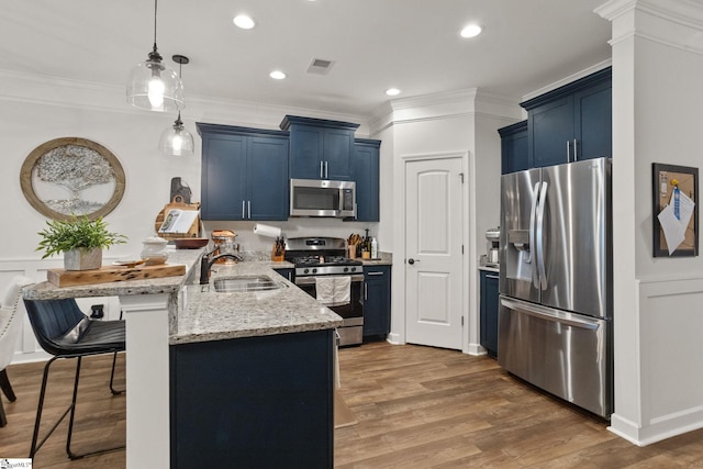 kitchen featuring visible vents, a peninsula, appliances with stainless steel finishes, and blue cabinets