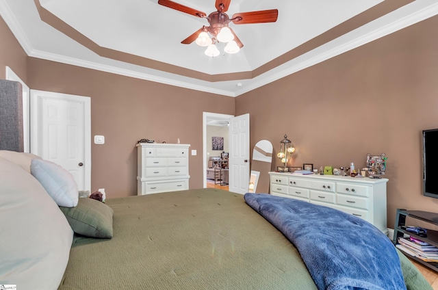 bedroom featuring a raised ceiling, ornamental molding, and ceiling fan