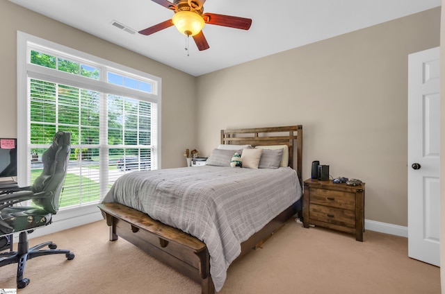 bedroom with baseboards, ceiling fan, light colored carpet, and visible vents
