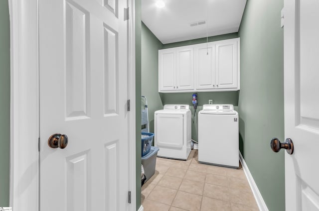 clothes washing area with visible vents, cabinet space, light tile patterned floors, baseboards, and washer and dryer