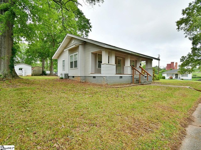 215 Louisiana St, Honea Path, SC 29654 - bungalow-style home featuring covered porch, crawl space, a front yard, an outbuilding, and central air condition unit