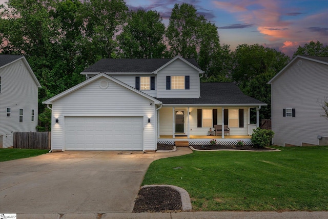 traditional home featuring a garage, fence, covered porch, a front yard, and driveway