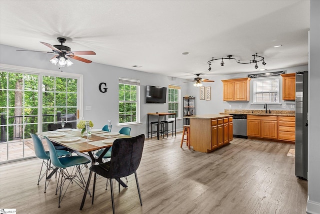 dining space featuring a ceiling fan and light wood finished floors
