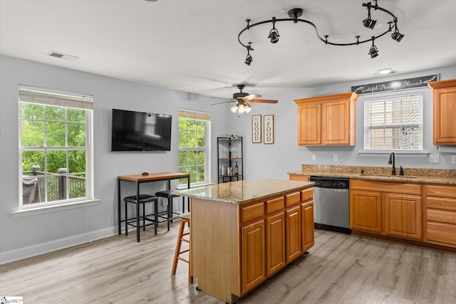 kitchen featuring light wood-style floors, plenty of natural light, a sink, and dishwasher