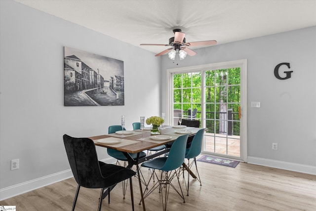 dining space with baseboards, a ceiling fan, and light wood finished floors