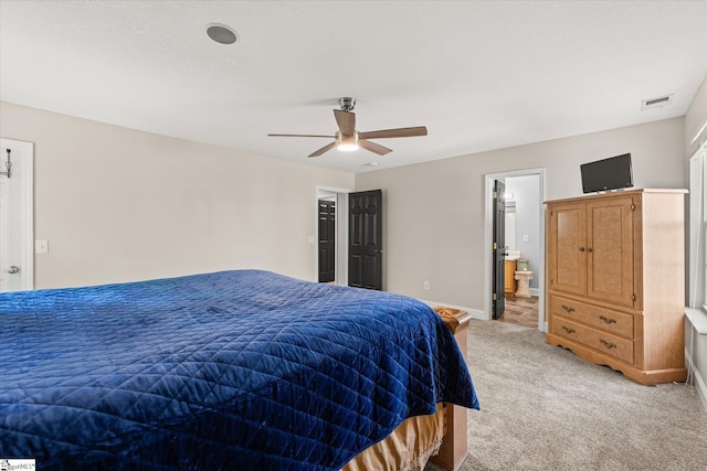 bedroom featuring visible vents, baseboards, ceiling fan, light colored carpet, and connected bathroom